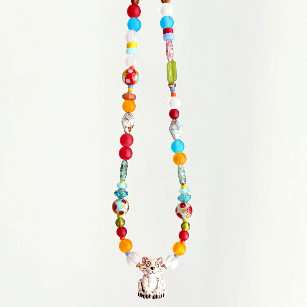 Colorful beaded necklace with a cat-shaped pendant on a white background