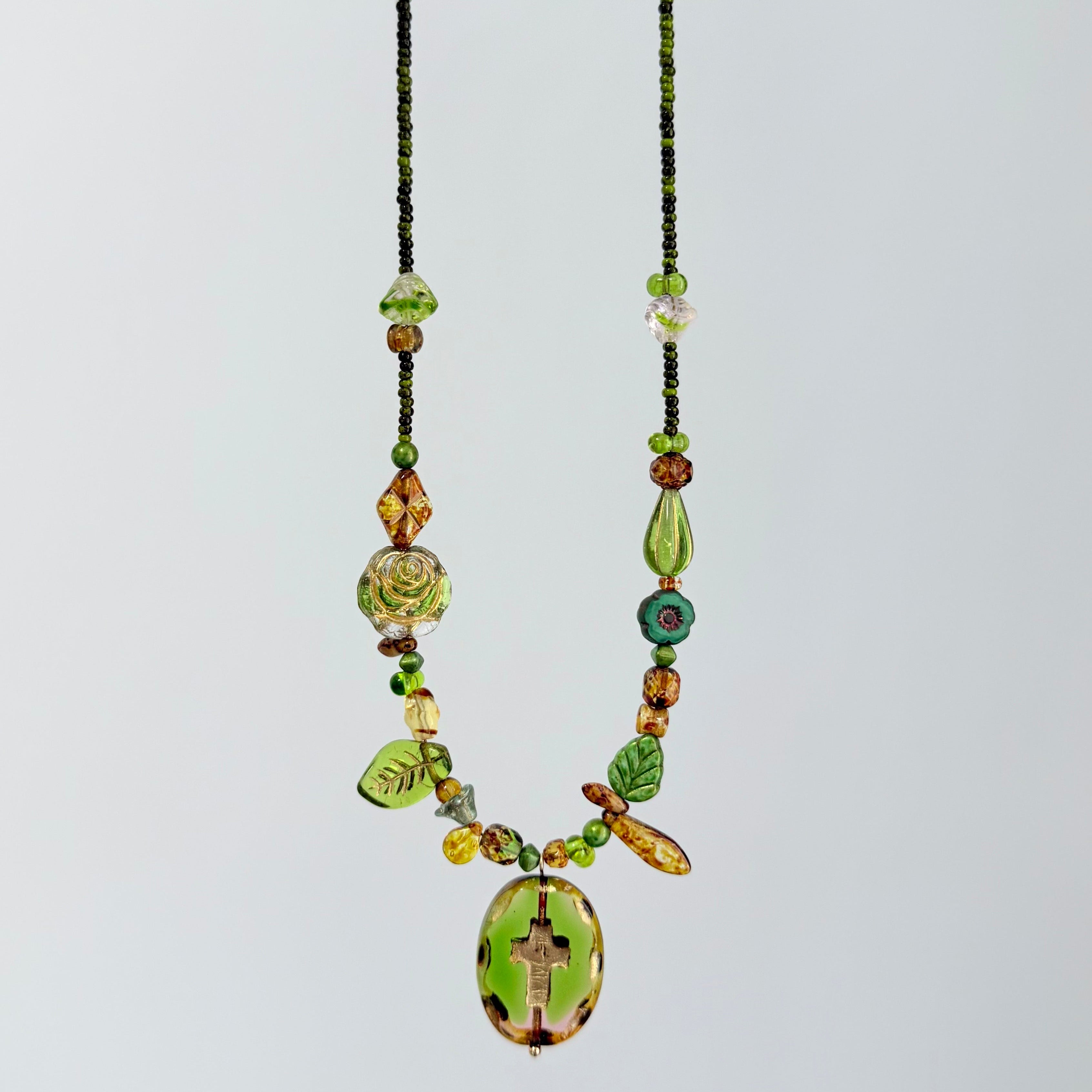 Necklace with green and brown beads on a light gray background