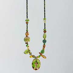 Necklace with green and brown beads on a light gray background